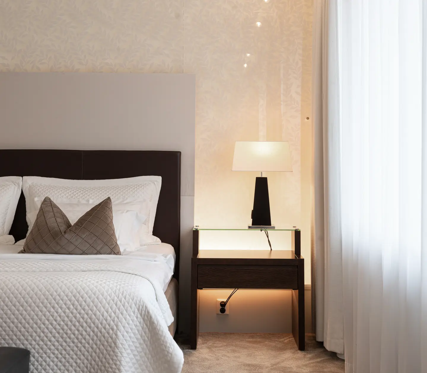 Ljust hotellrum med säng, skrivbord och tv