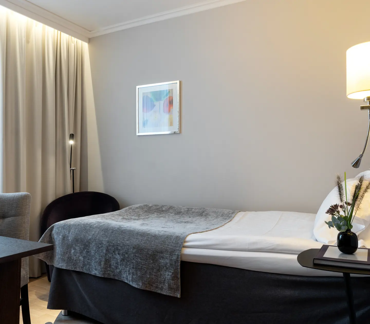 Hotellrum med enkelsäng och skrivbord