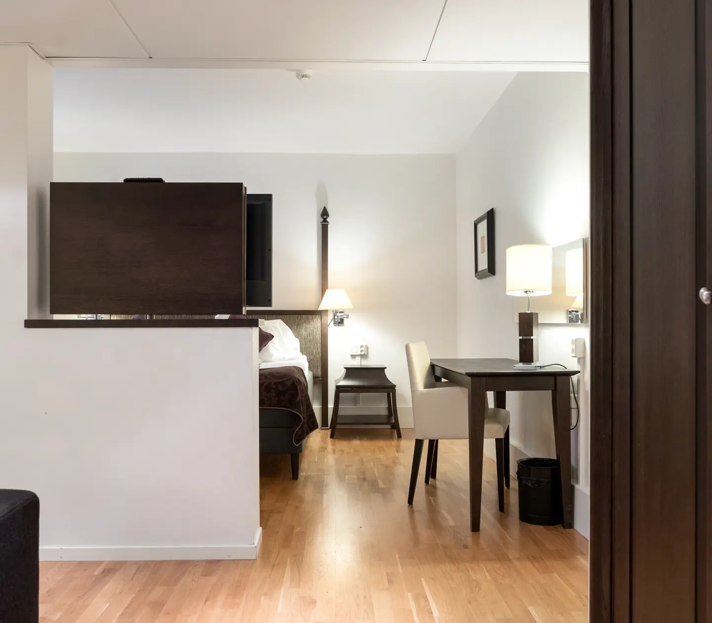 Ljus svit med säng, skrivbord och tv