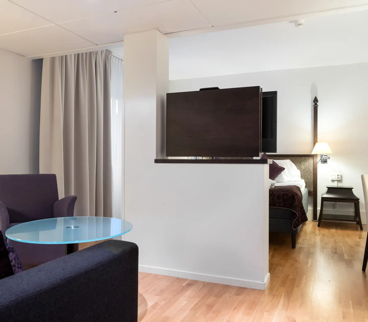 Ljus svit med säng, skrivbord och soffgrupp
