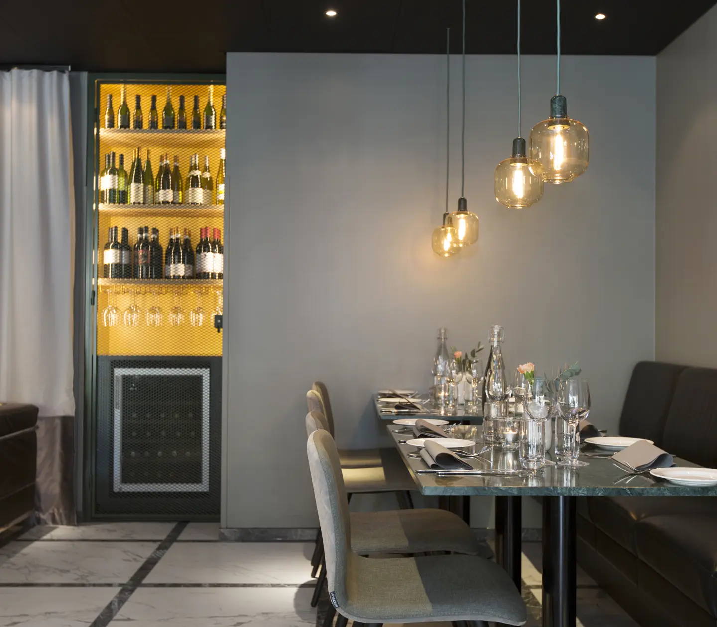 Restaurangmiljö med matgrupper, vinflaskor och taklampor
