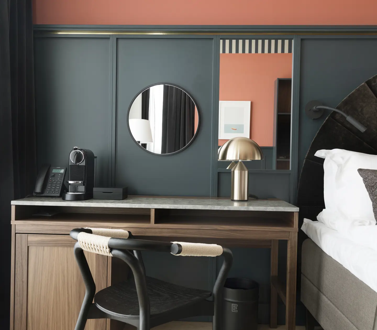 Mysigt hotellrum med säng, skrivbord, blå och röd vägg