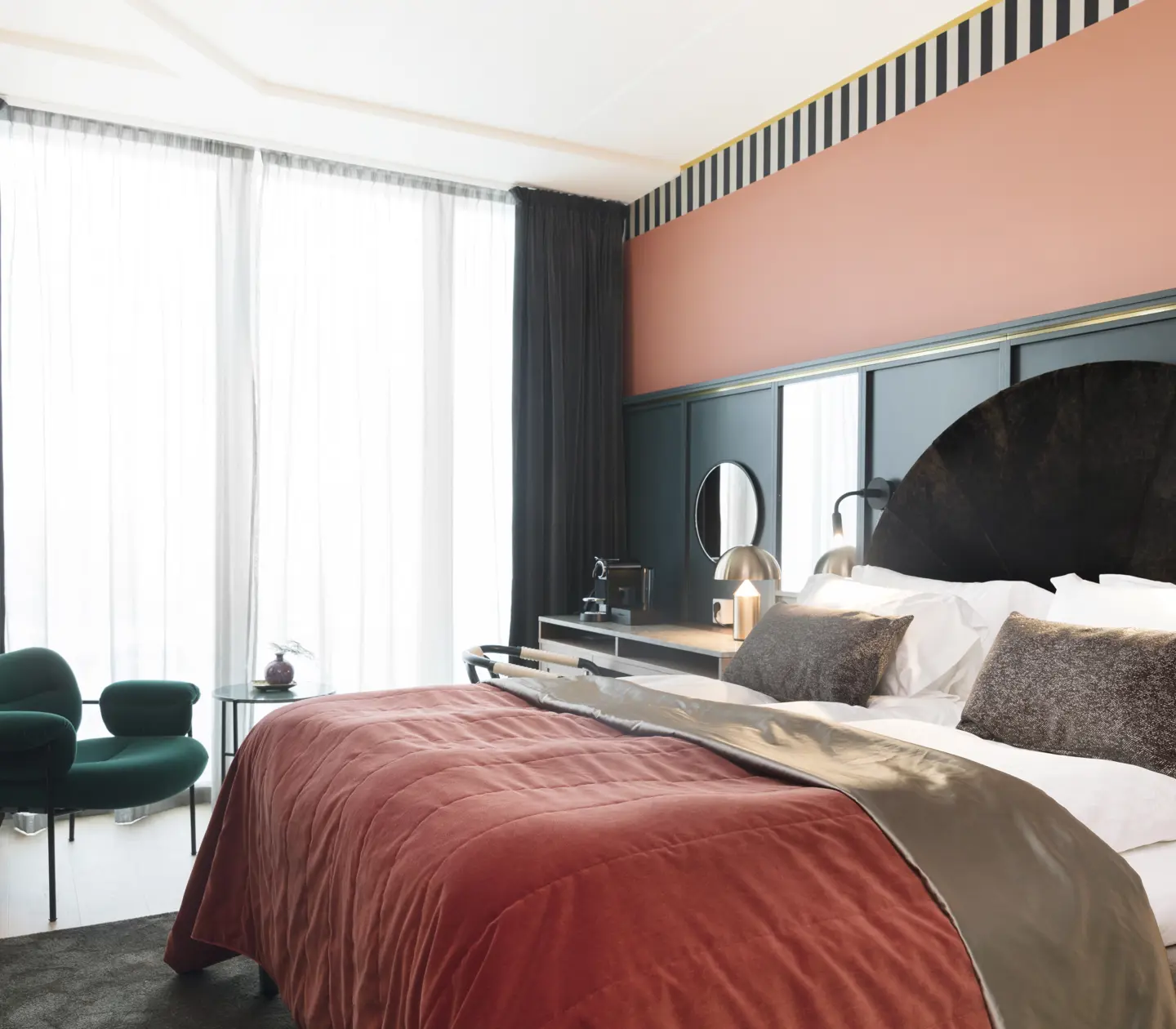 Mysigt hotellrum med säng, skrivbord och stort fönster
