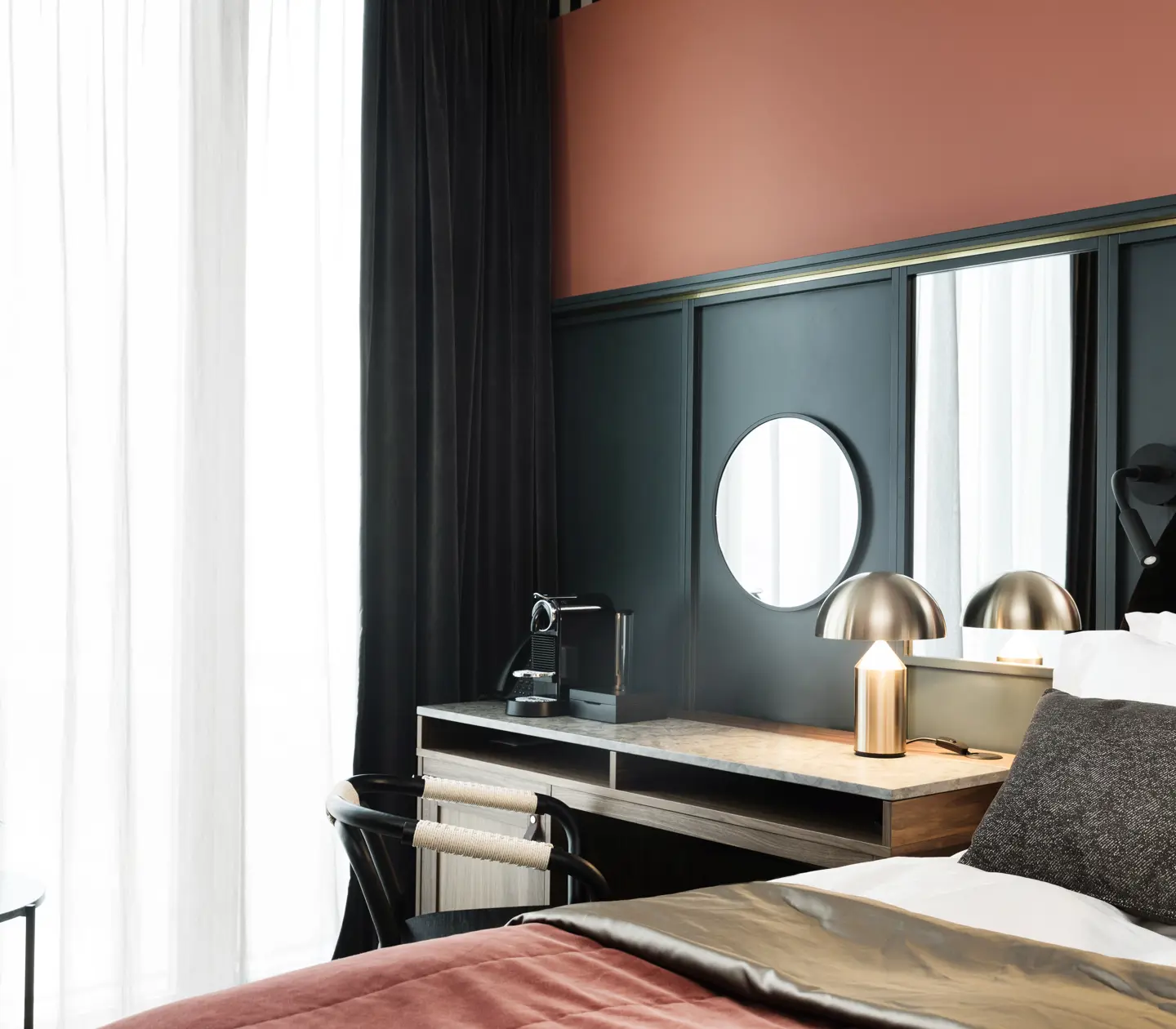 Mysigt hotellrum med säng, skrivbord, blå och röd vägg