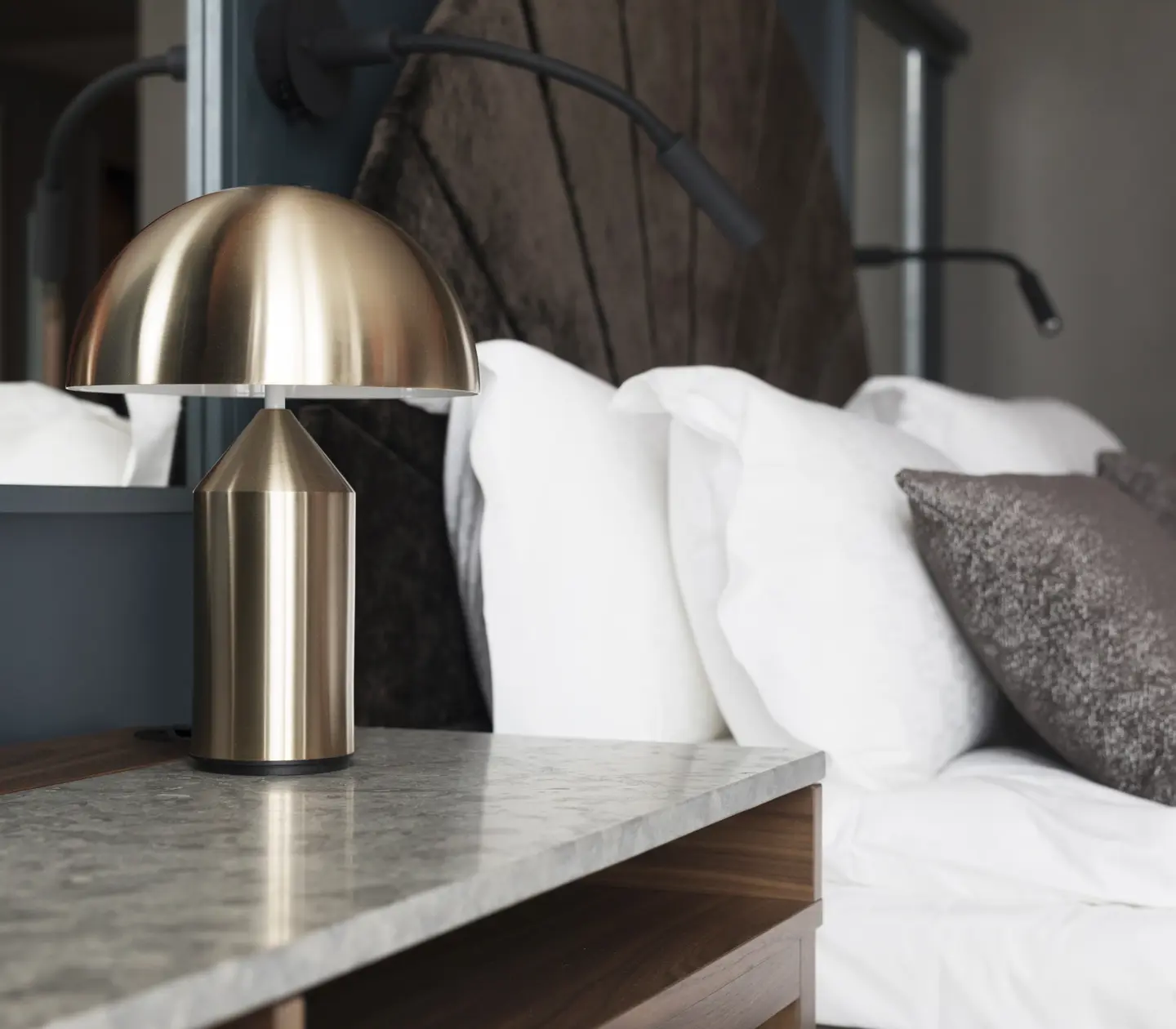 Mysigt hotellrum med säng, spegel och sänglampor
