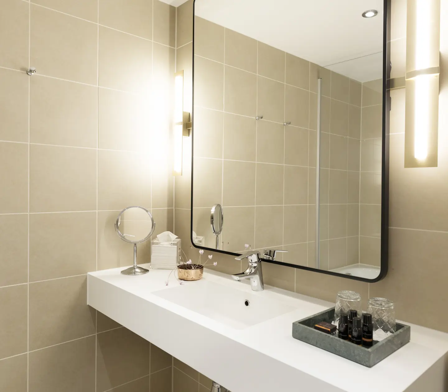Beige badrum med handfat och spegel