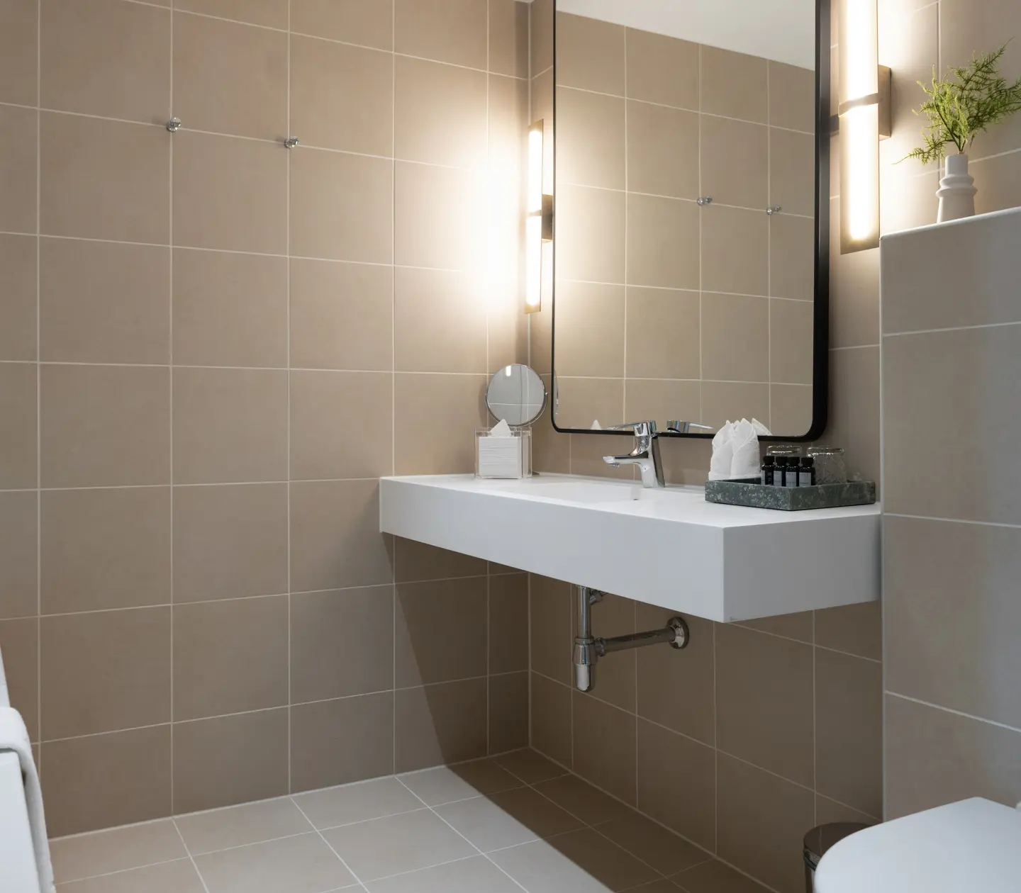 Beige badrum med badkar, handfat och spegel