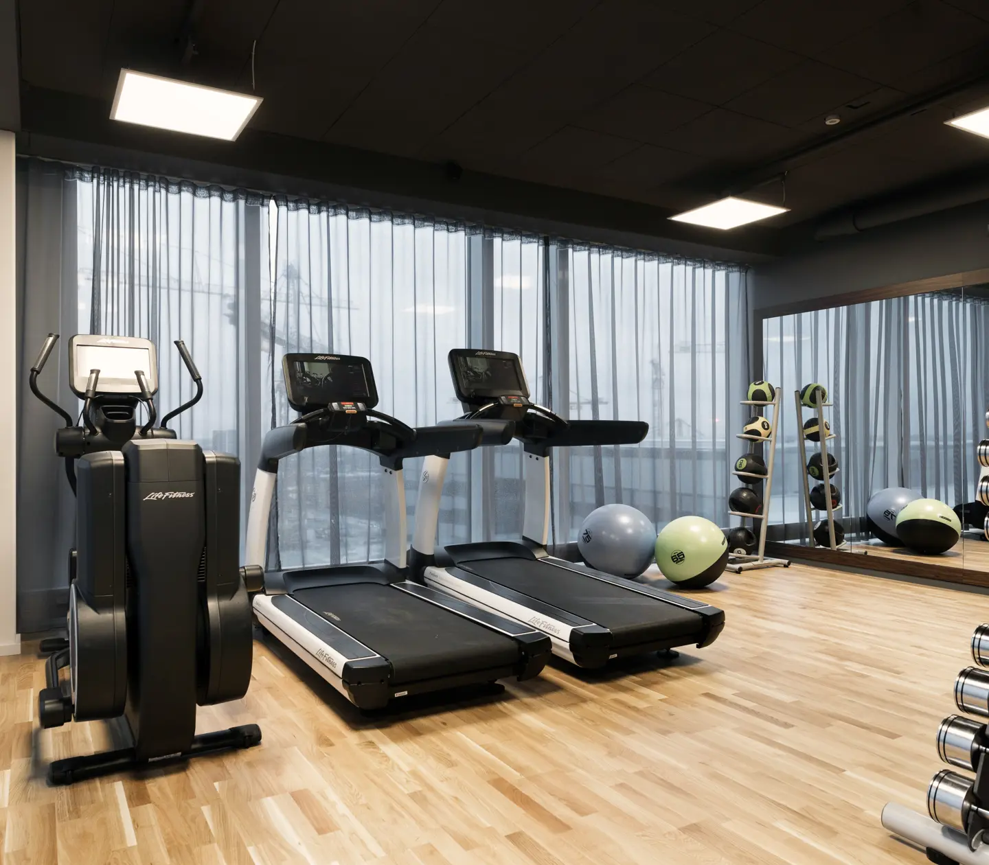 Gymmiljö med löpband, hantlar och gardiner