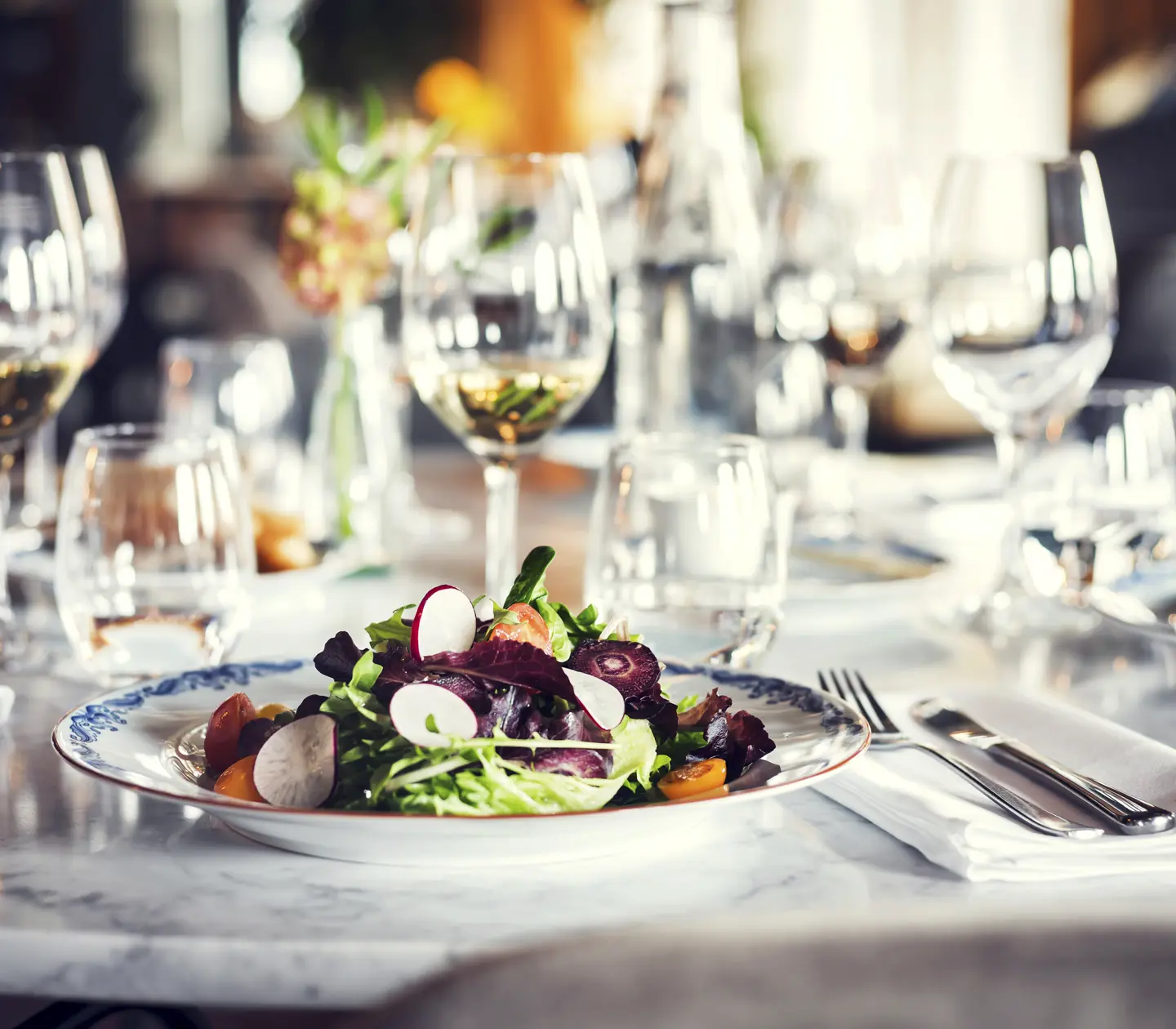 Mat serverad på tallrik på bord med fler tallrikar och glas