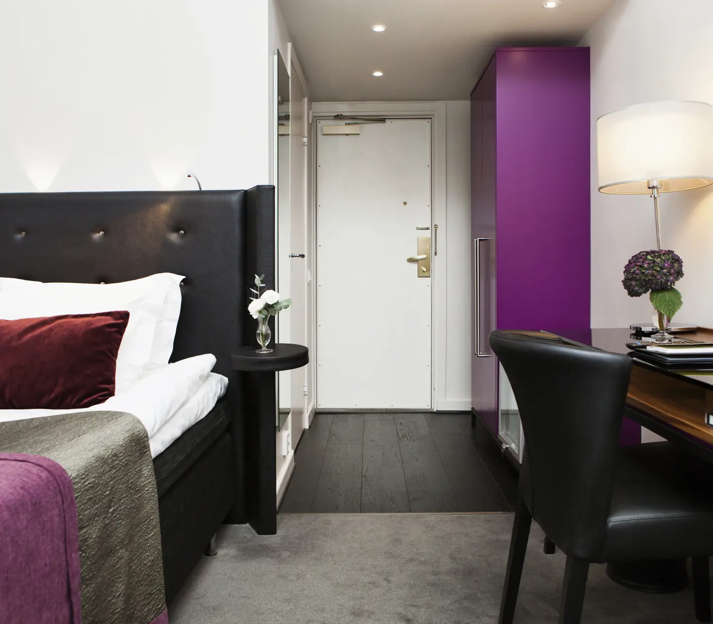 Hotellrum med enkelsäng, skrivbord och garderob