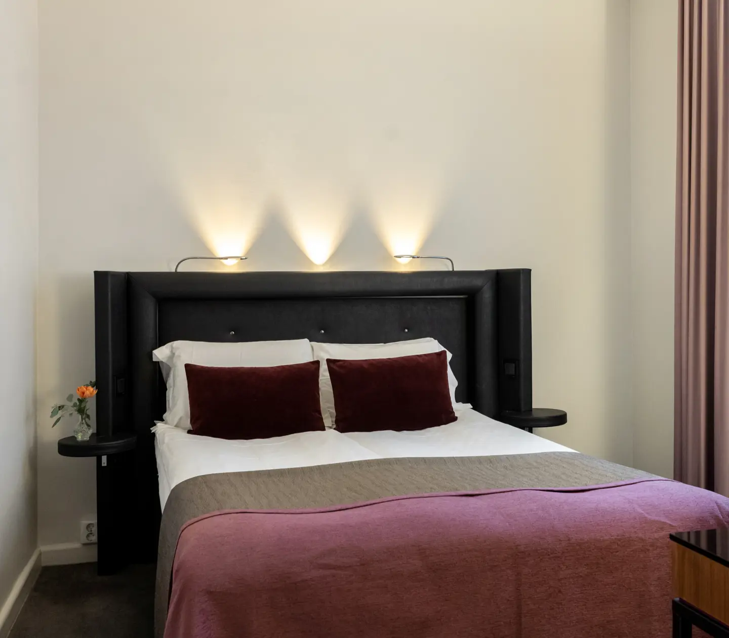 Hotellrum med dubbelsäng, tavla och fönster