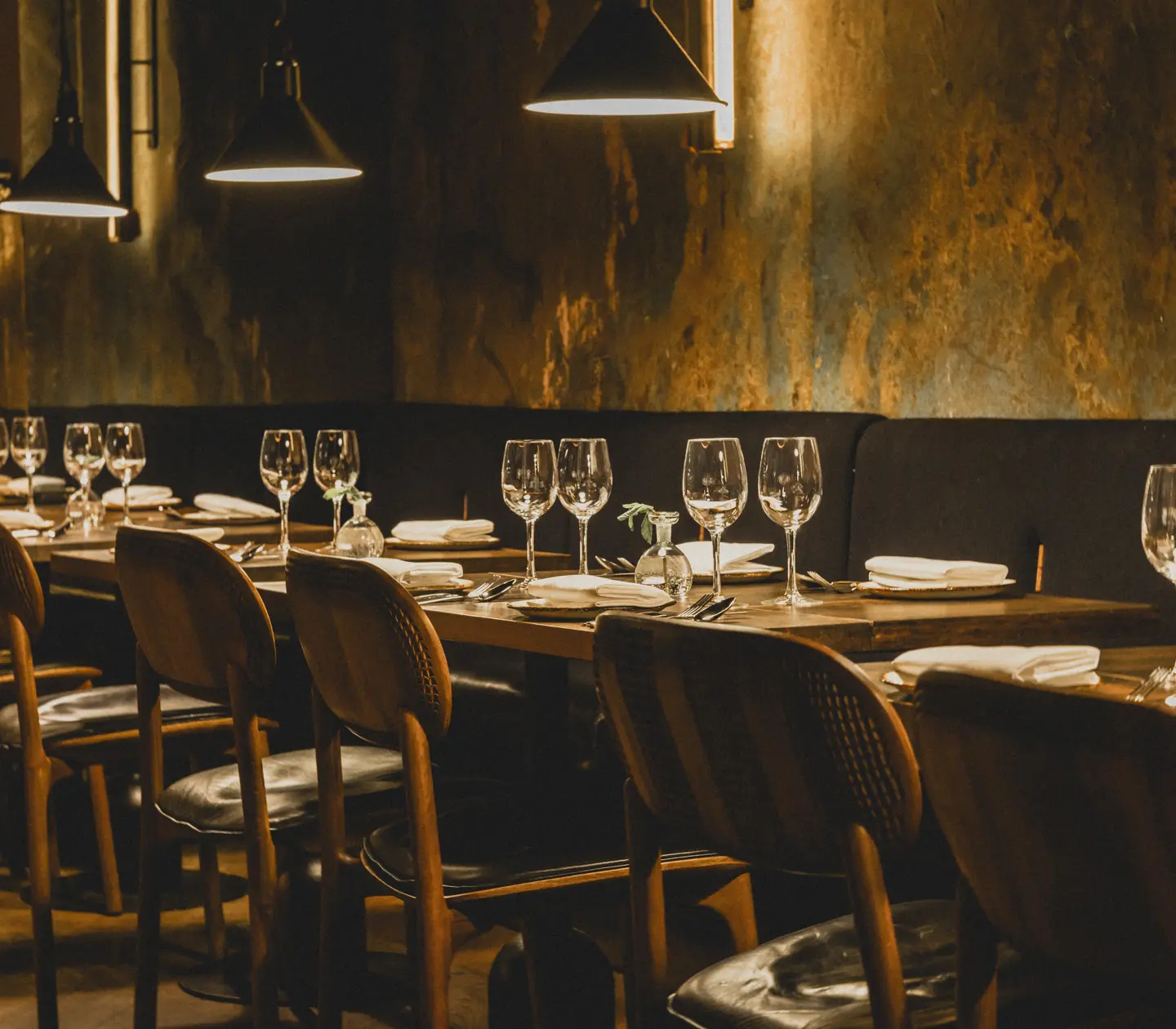 Mysig restaurangmiljö med många små bord och taklampor