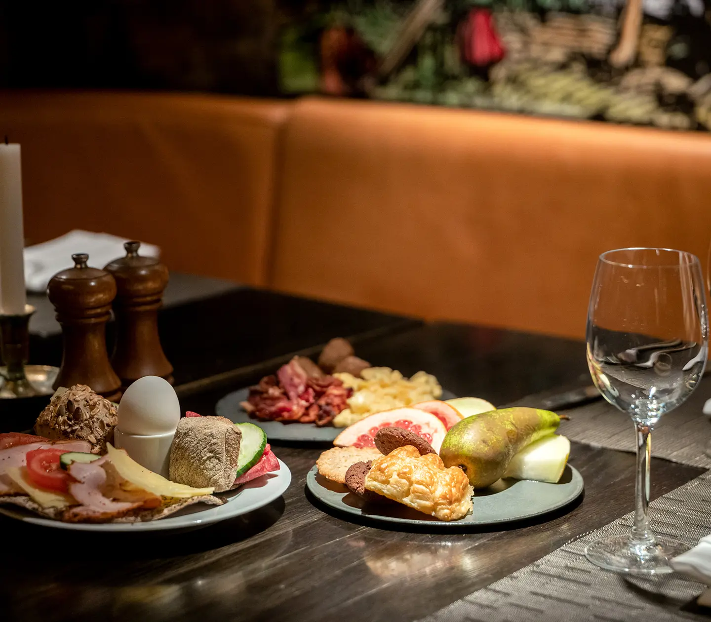 Restaurangbord med frukosttallrikar uppdukade med ägg, smörgåsar och frukt