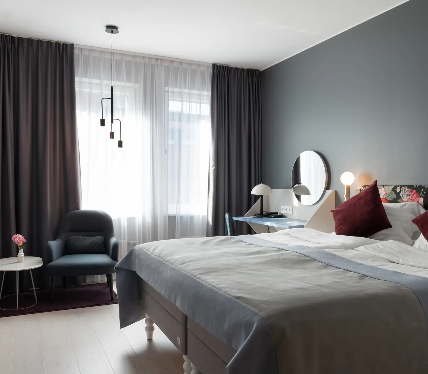 Dubbelsäng, fåtölj och tv i hotellrum