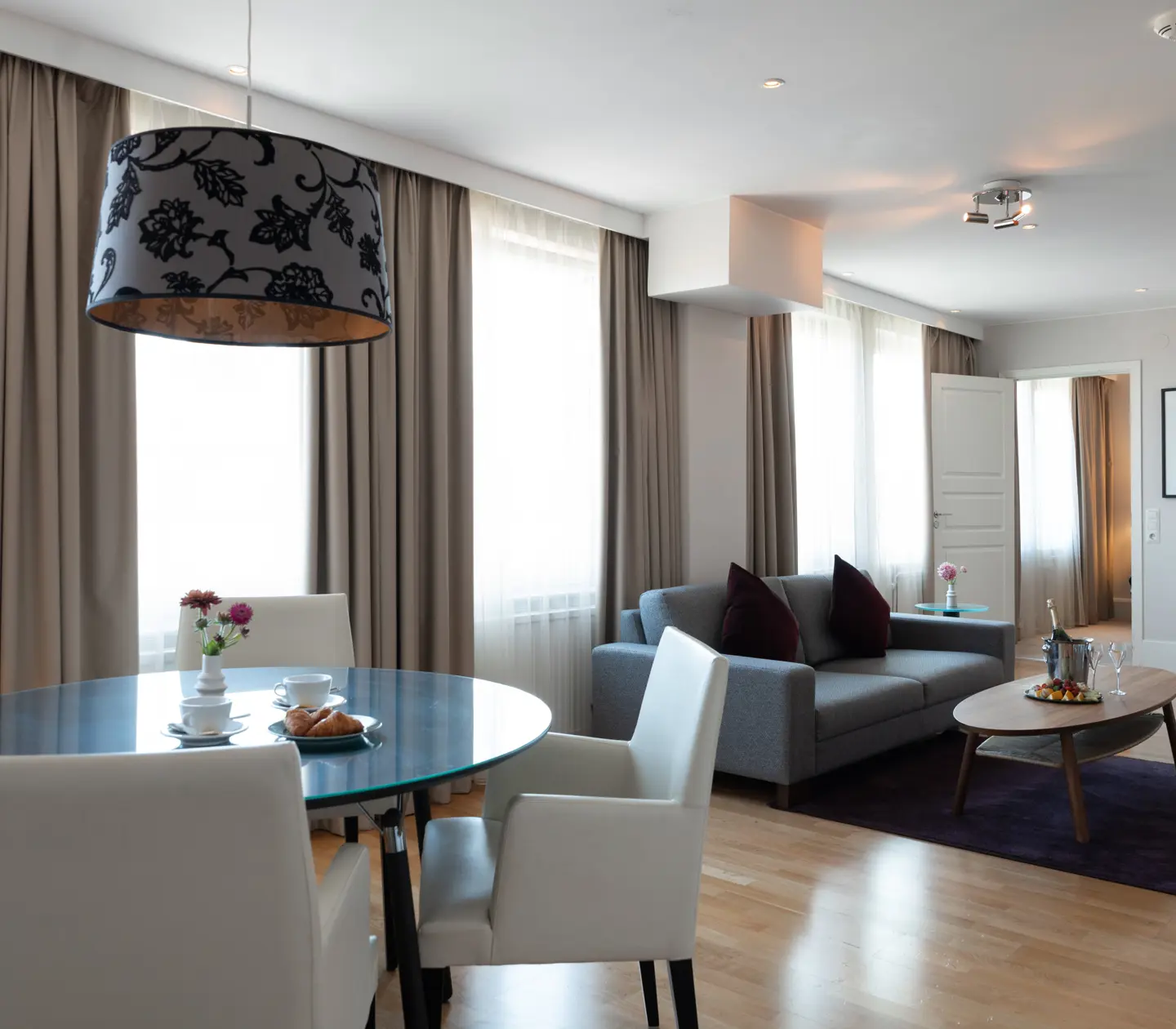 Vackert hotellrum med matgrupp och soffa