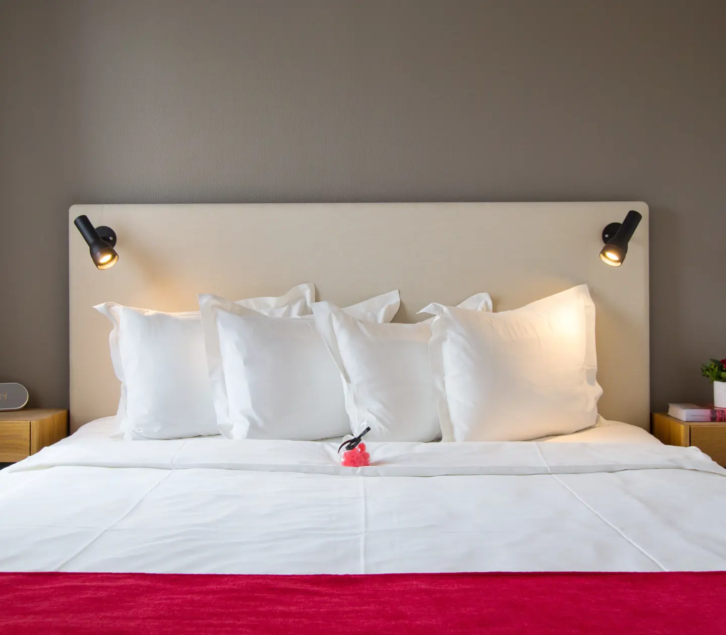 Mysigt hotellrum med säng, sänglampor och liten godispåse på sängen