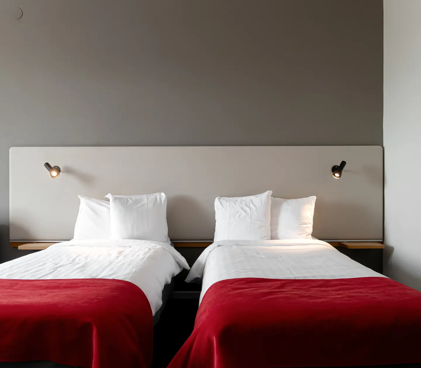 Mysigt hotellrum med sängar, kuddar och sänglampor