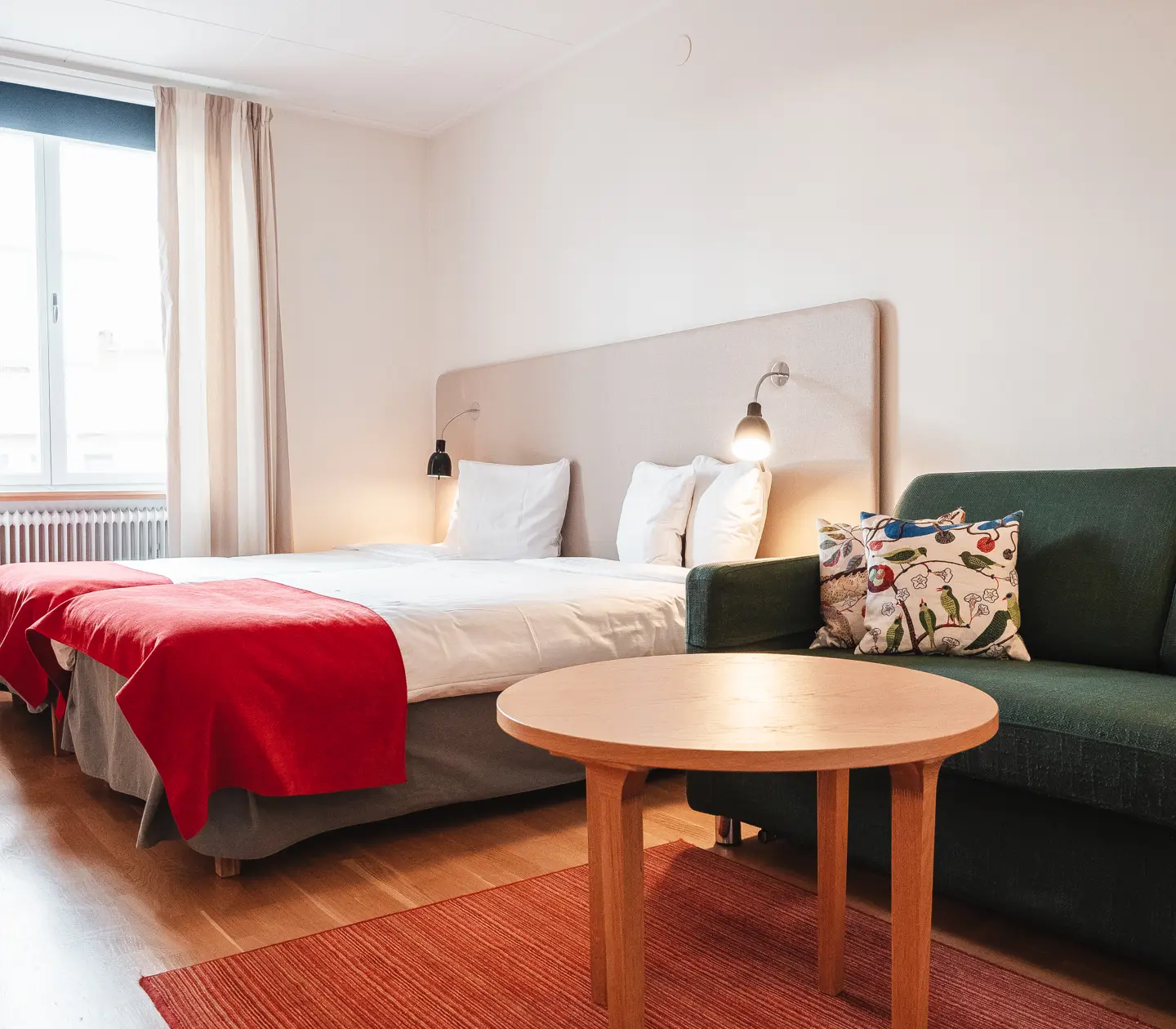 Mysigt hotellrum med säng, soffa och fönster