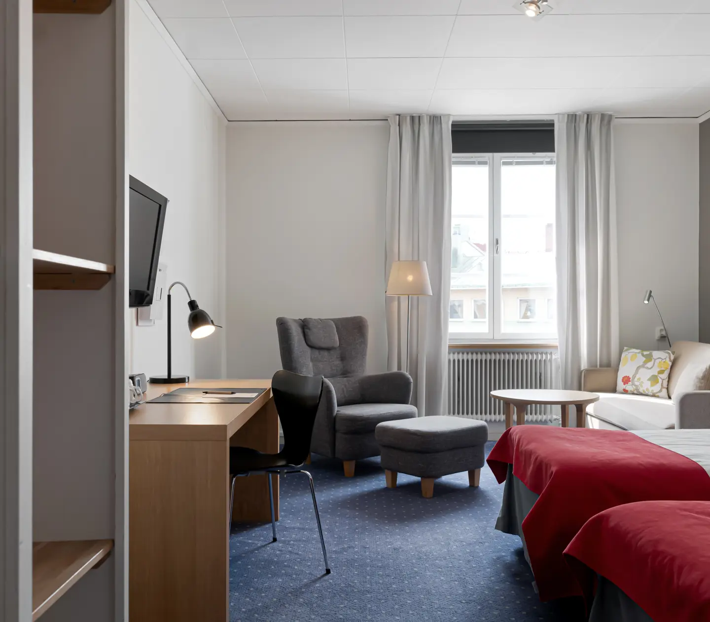 Hotellrum med säng, soffgrupp och skrivbord