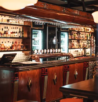 Pubmiljö med bardisk, glas och flaskor