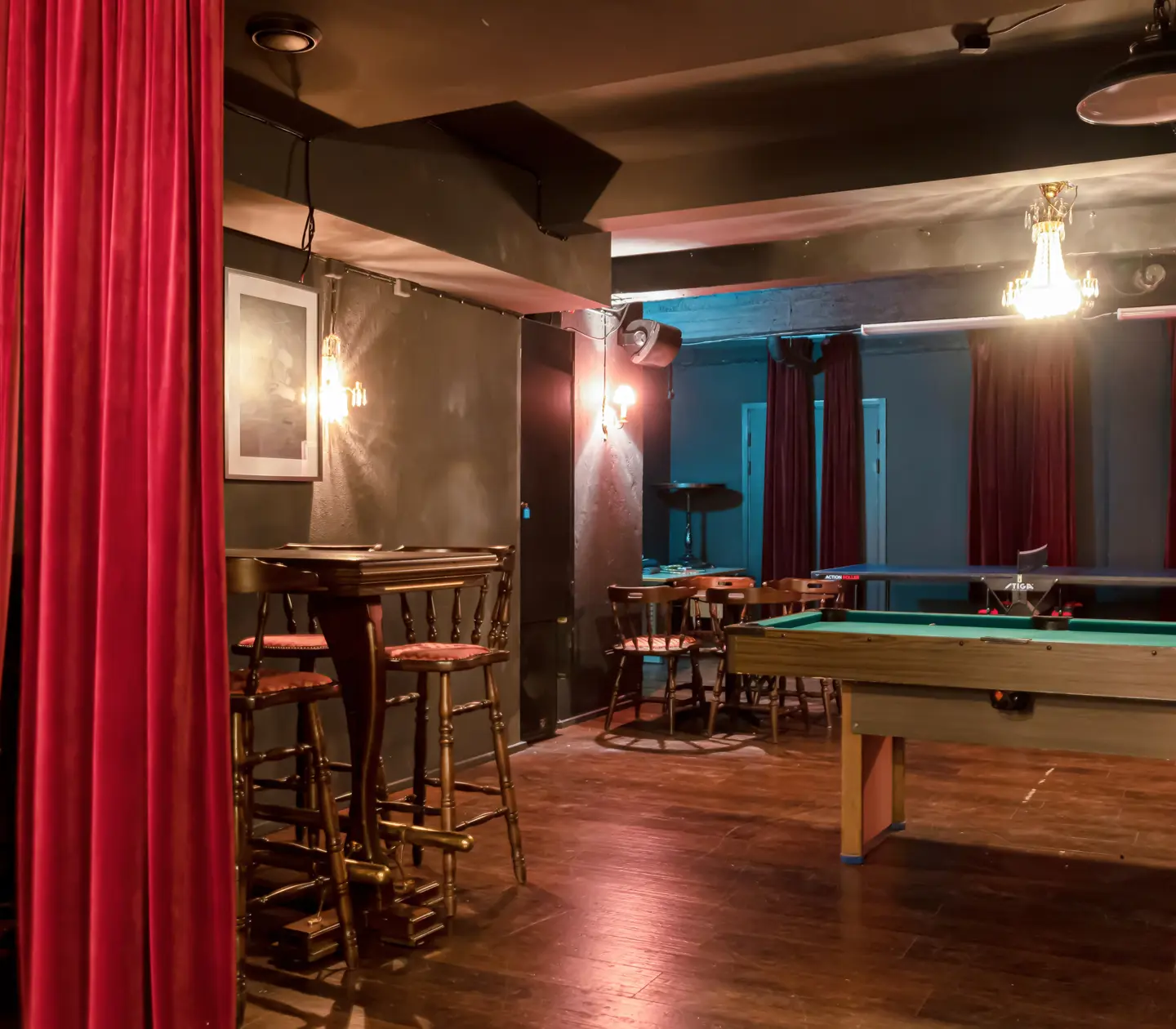 Pubmiljö med biljardbord, kristallkronor och sittplatser