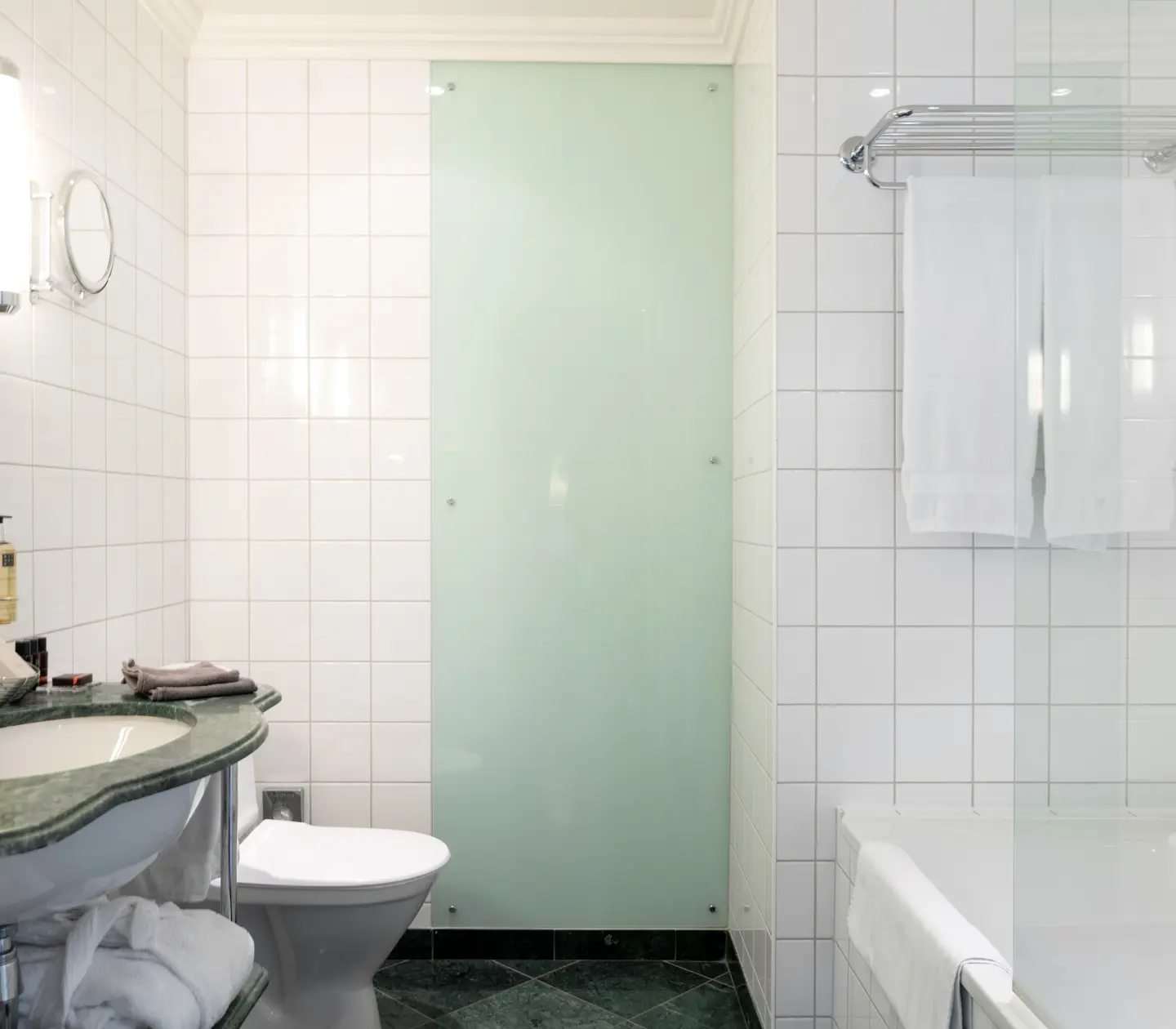 Ljust badrum med badkar, grönt handfat och toalett