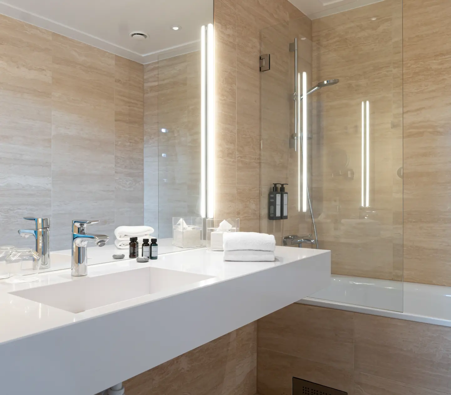 Beige badrum med badkar, handfat och spegel