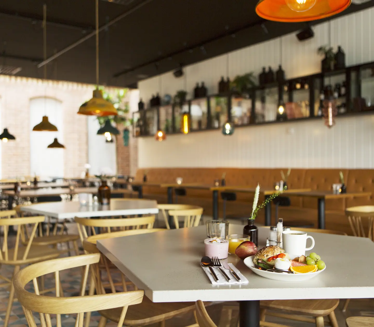 Restaurangmiljö med frukost serverad på bord och matgrupper i bakgrunden