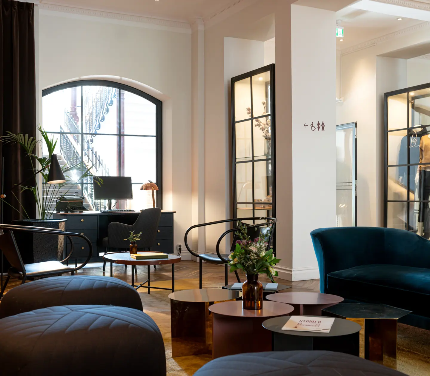 Hotellobby med blombukett, loungemöbler och skrivbord