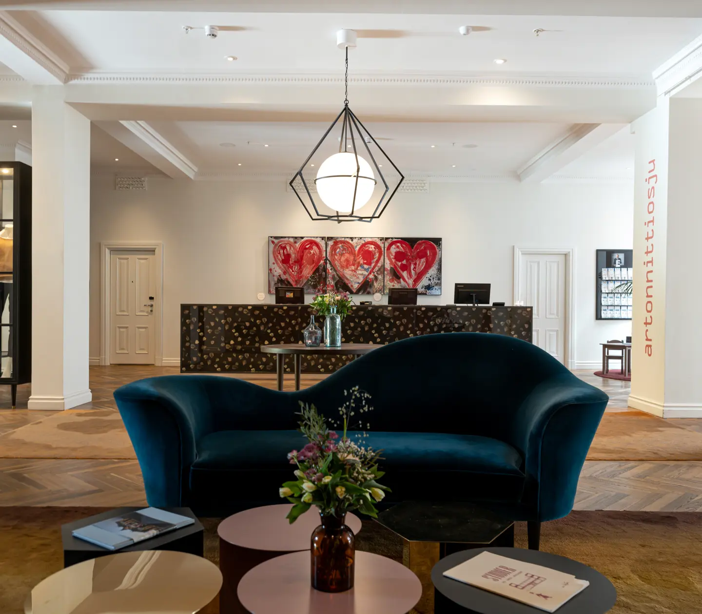 Hotellobby med blombuketter, loungemöbler och receptionsdisk