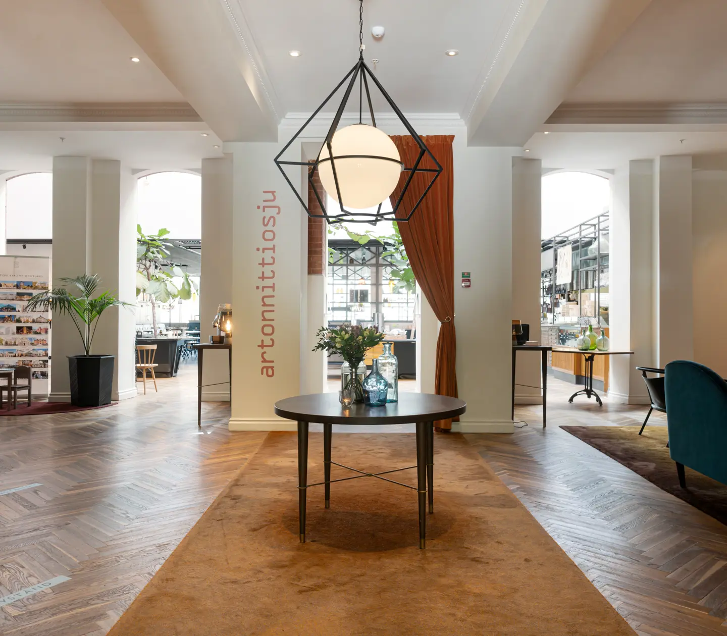 Hotellobby med loungemöbler, receptionsdisk och restaurang i bakgrunden