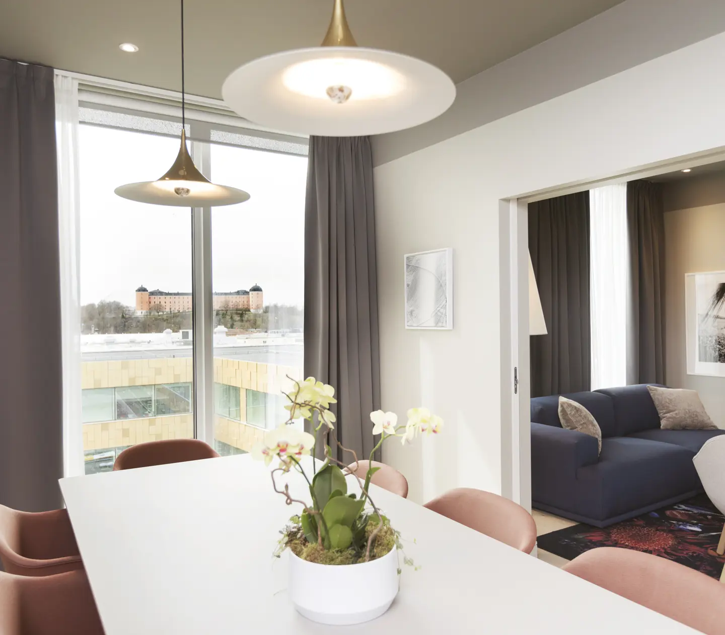 Mysig svit med matgrupp, soffgrupp och stort fönster