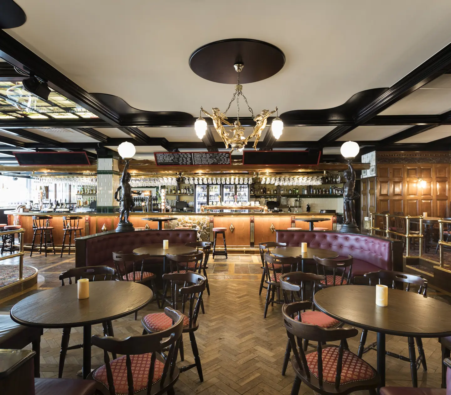 Pubmiljö med runda bord, bar och dekorationer i tak