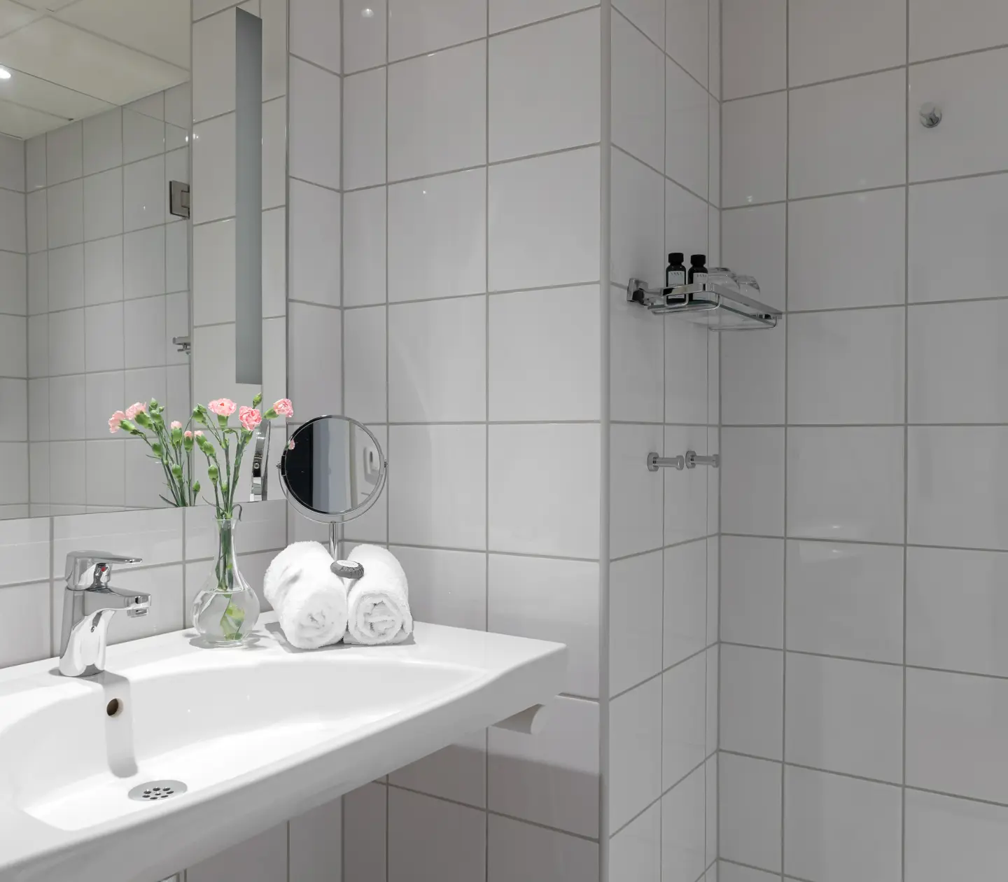 Ljust badrum med handdukar, handfat och spegel