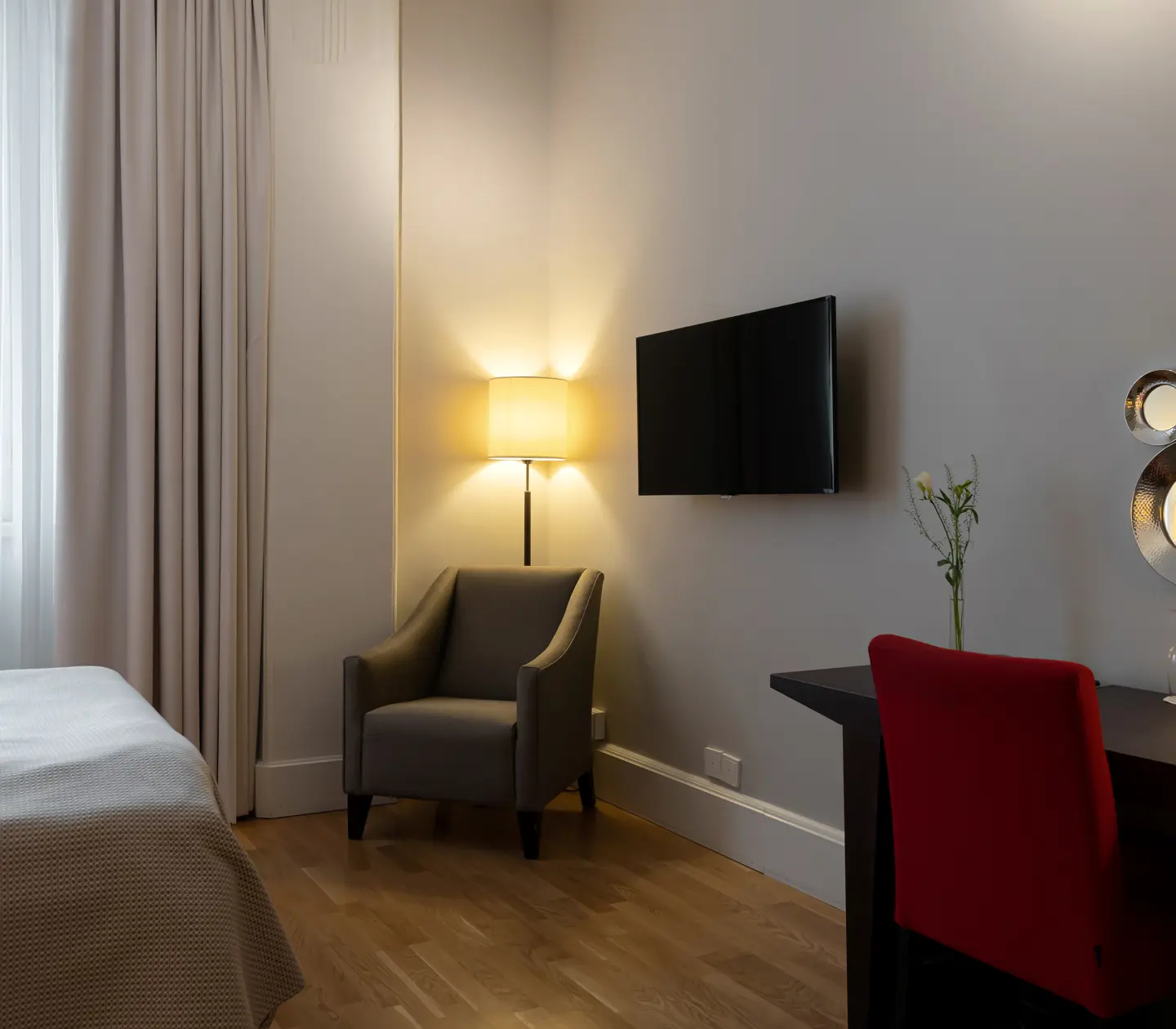 Hotellrum med skrivbord, fönster och fåtölj