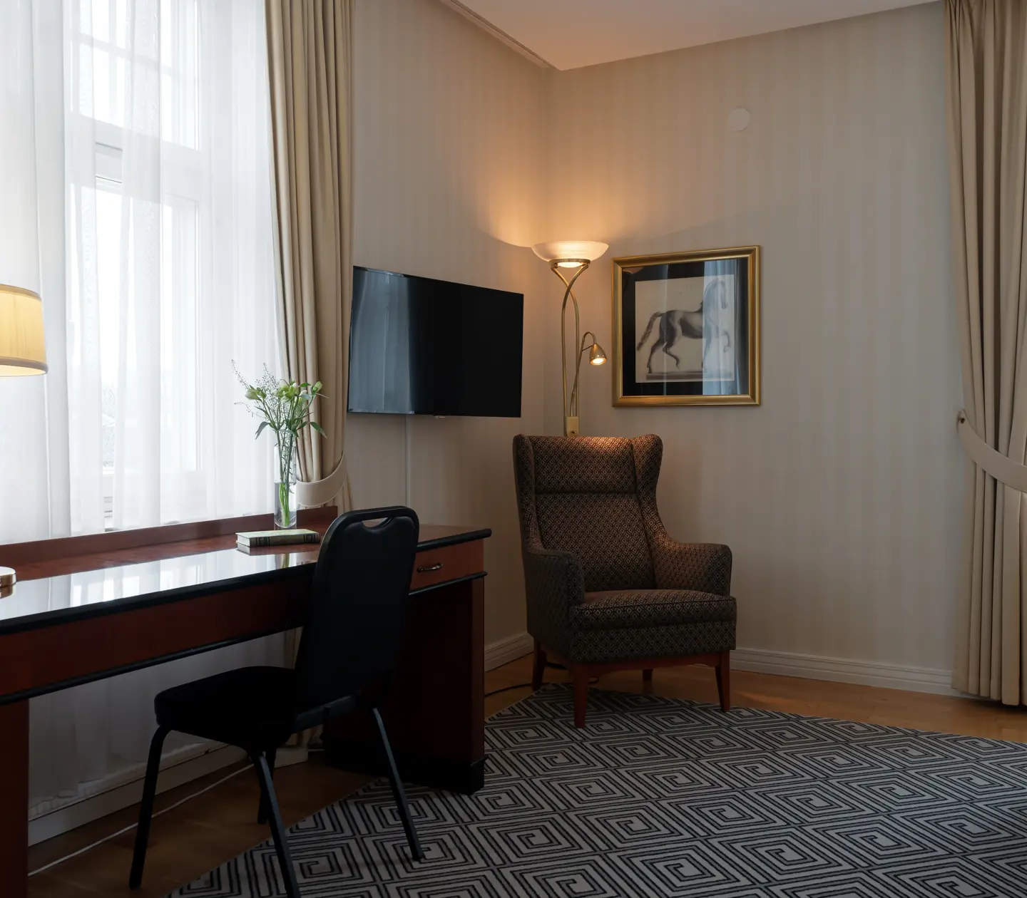 Mysig svit med skrivbord, fåtölj och fönster