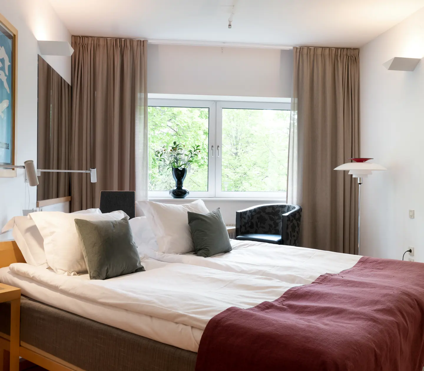 Mysigt hotellrum med dubbelsäng och fönster