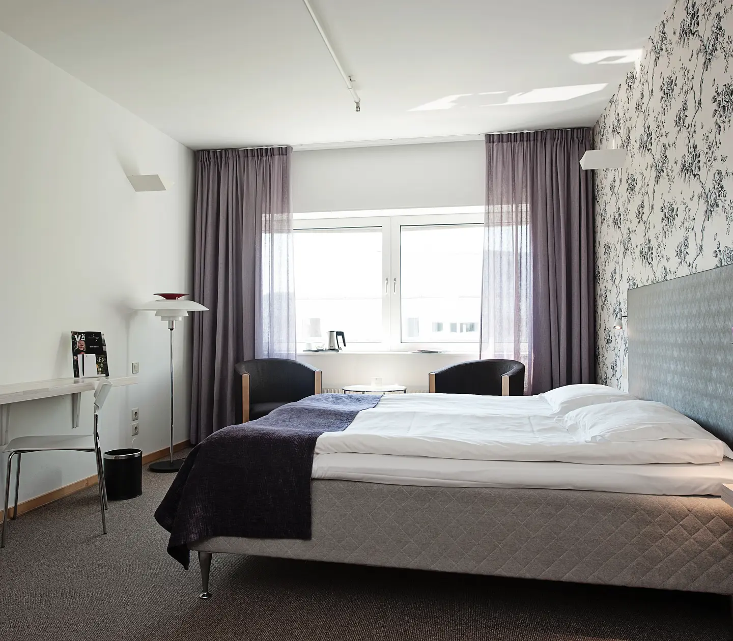 Ljust hotellrum med blommiga tapeter