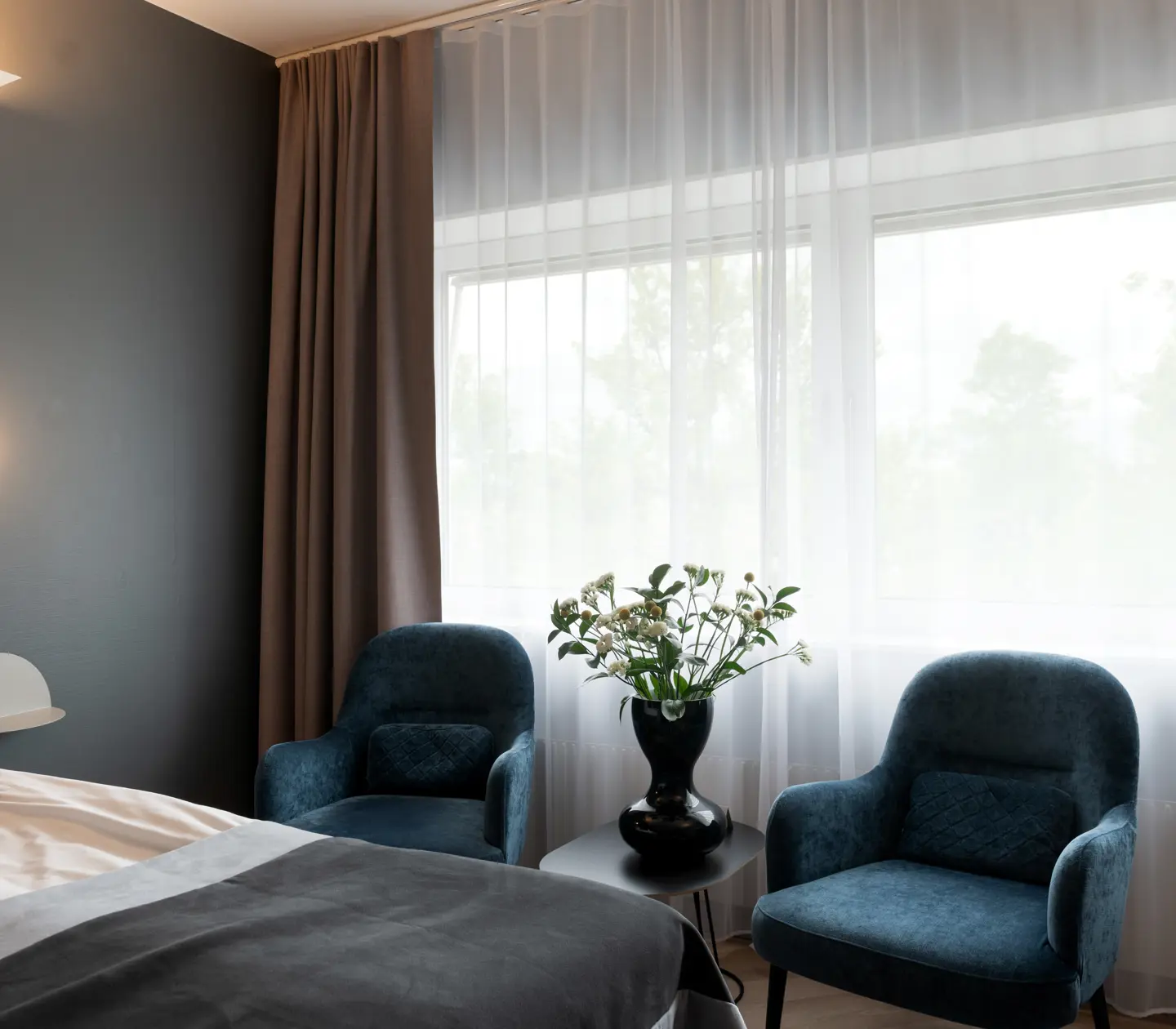 Mysigt hotellrum med fåtöljer och fönster