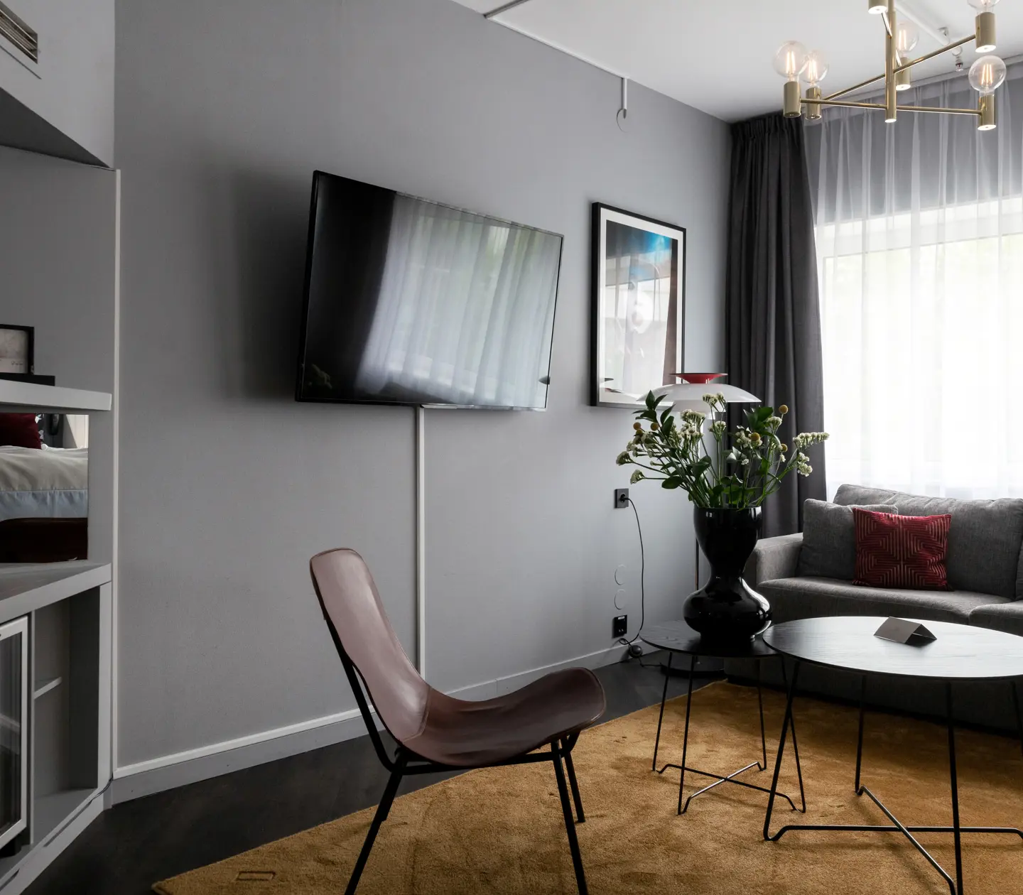 Hotellrum med soffa, tv och fönster