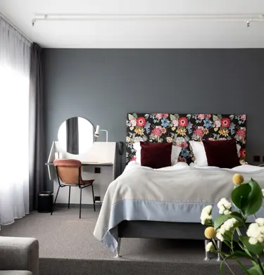 Hotellrum med dubbelsäng och sänglampor