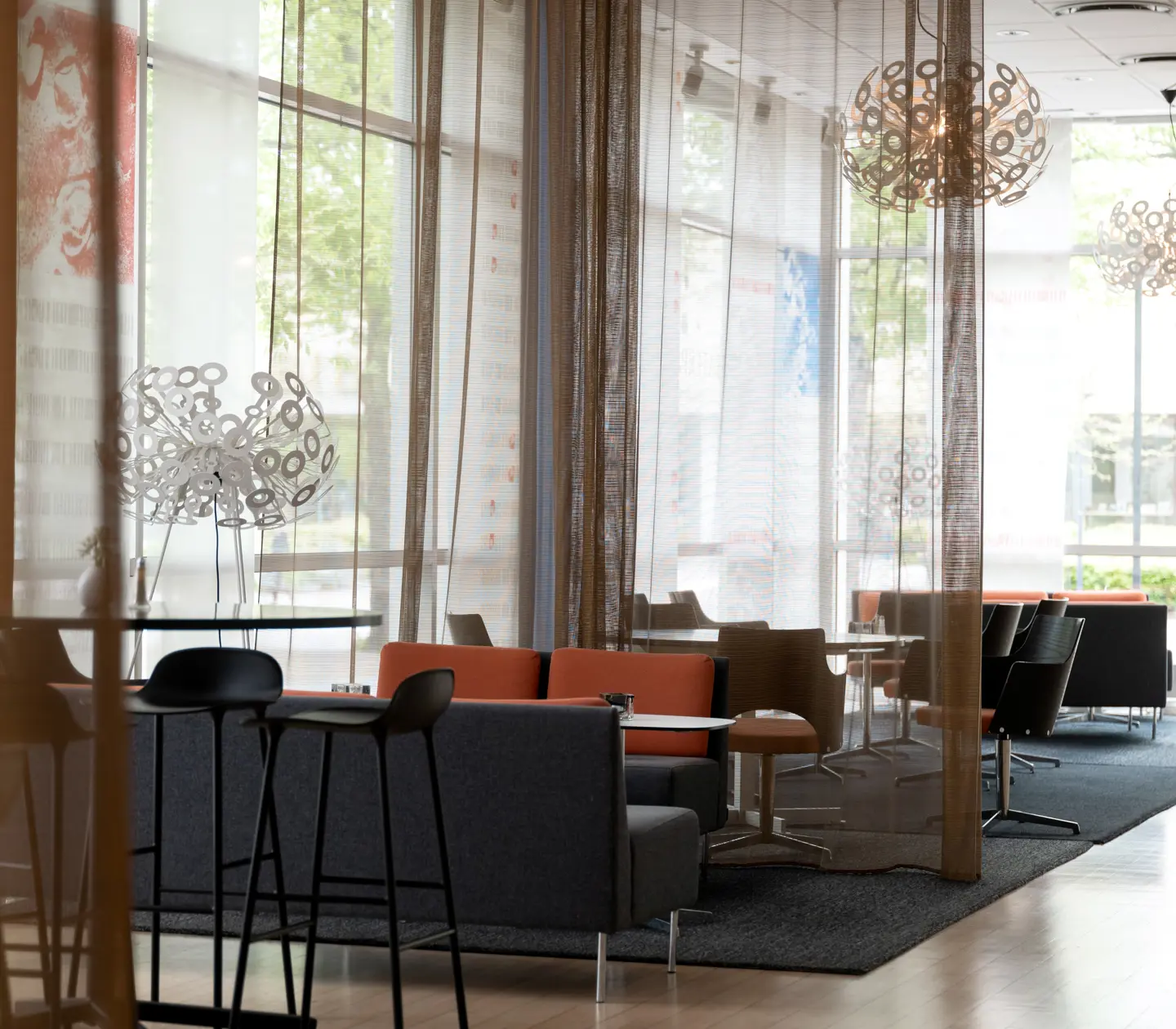 Hotellobby med loungestolar och stora fönster