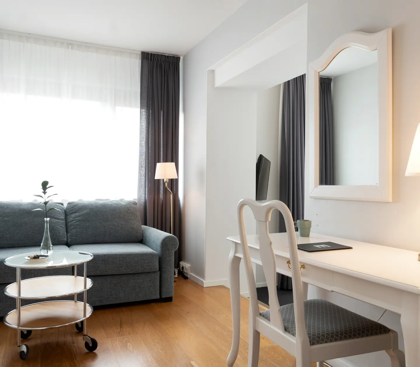 Hotellrum med skrivbord, soffa och fönster