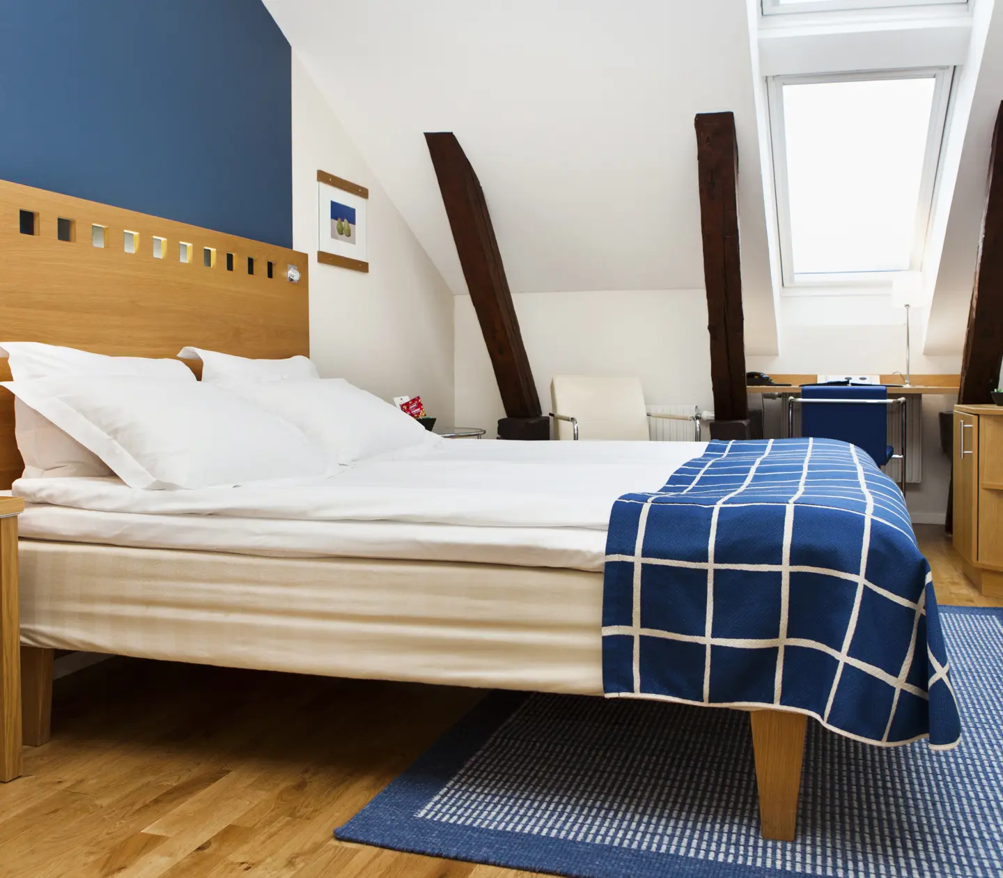 Färgglatt hotellrum med dubbelsäng och takfönster