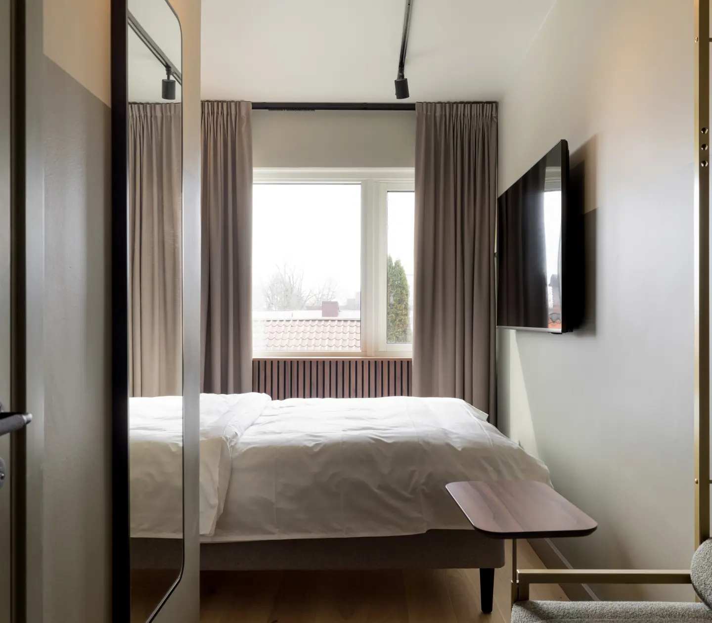 Hotellrum med dubbelsäng, fönster och tv