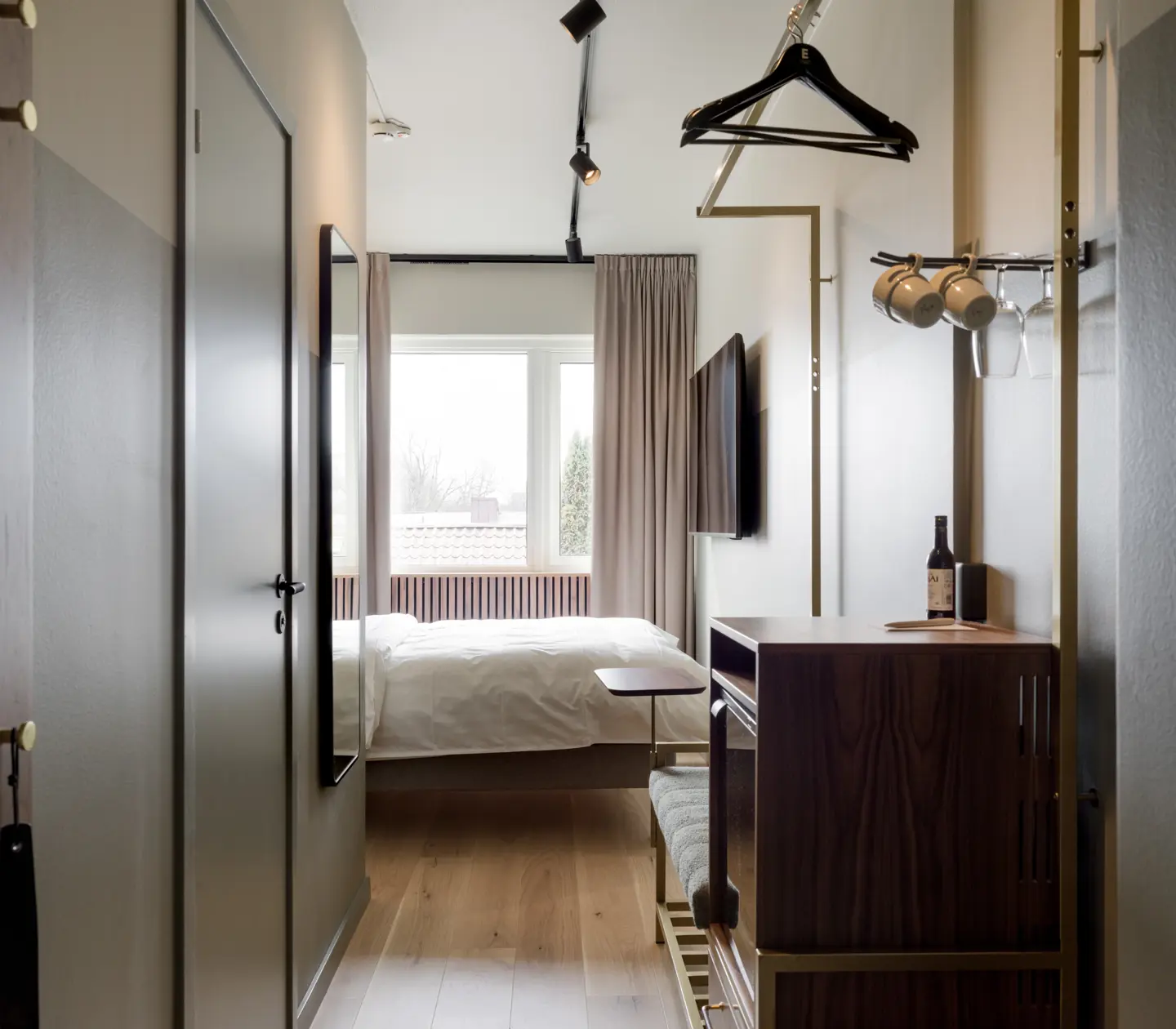 Hotellrum med dubbelsäng, tv och fönster