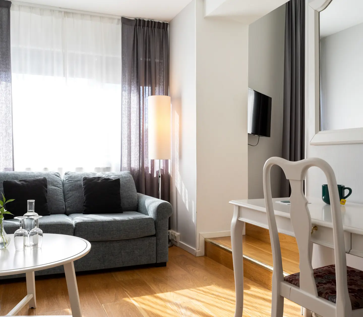 Hotellrum med soffa, skrivbord och fönster