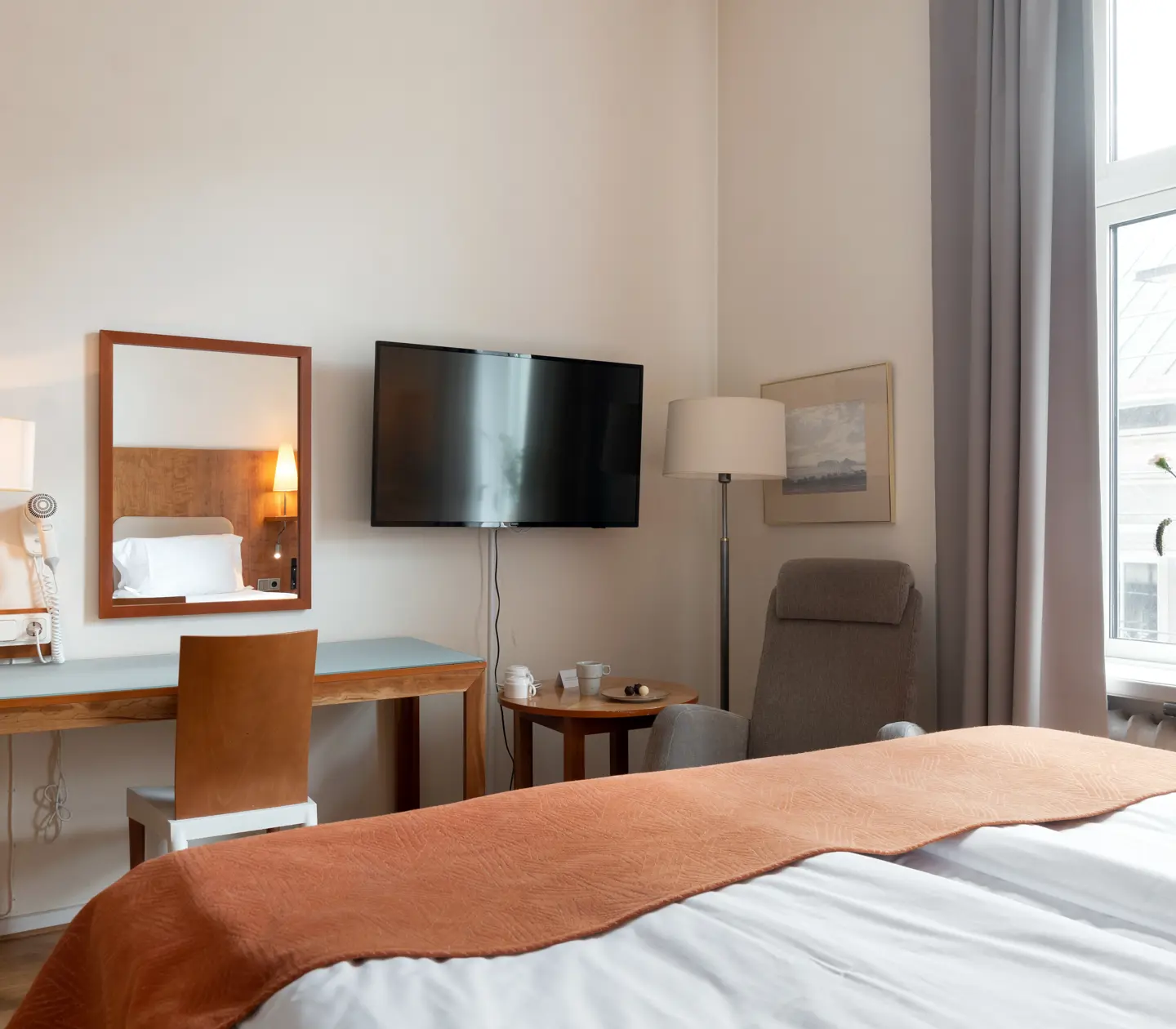 Mysigt hotellrum med skrivbord, fönster och tv