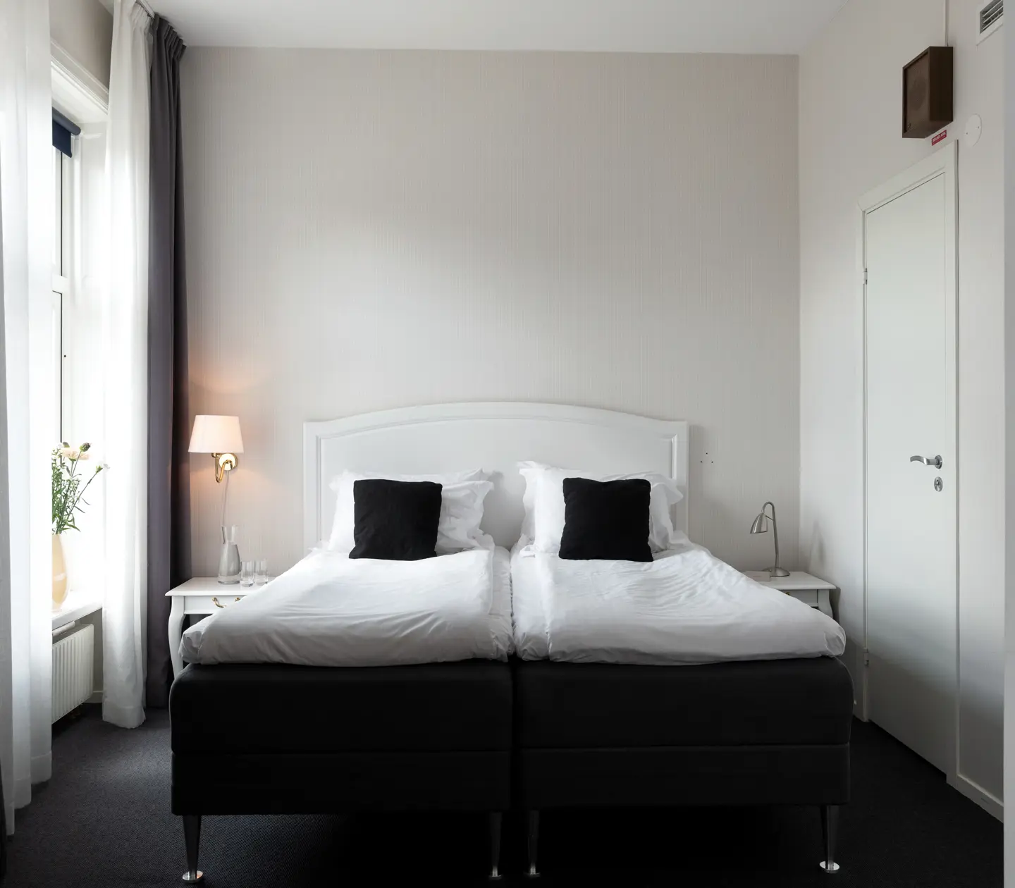 Ljust hotellrum med dubbelsäng och fönster