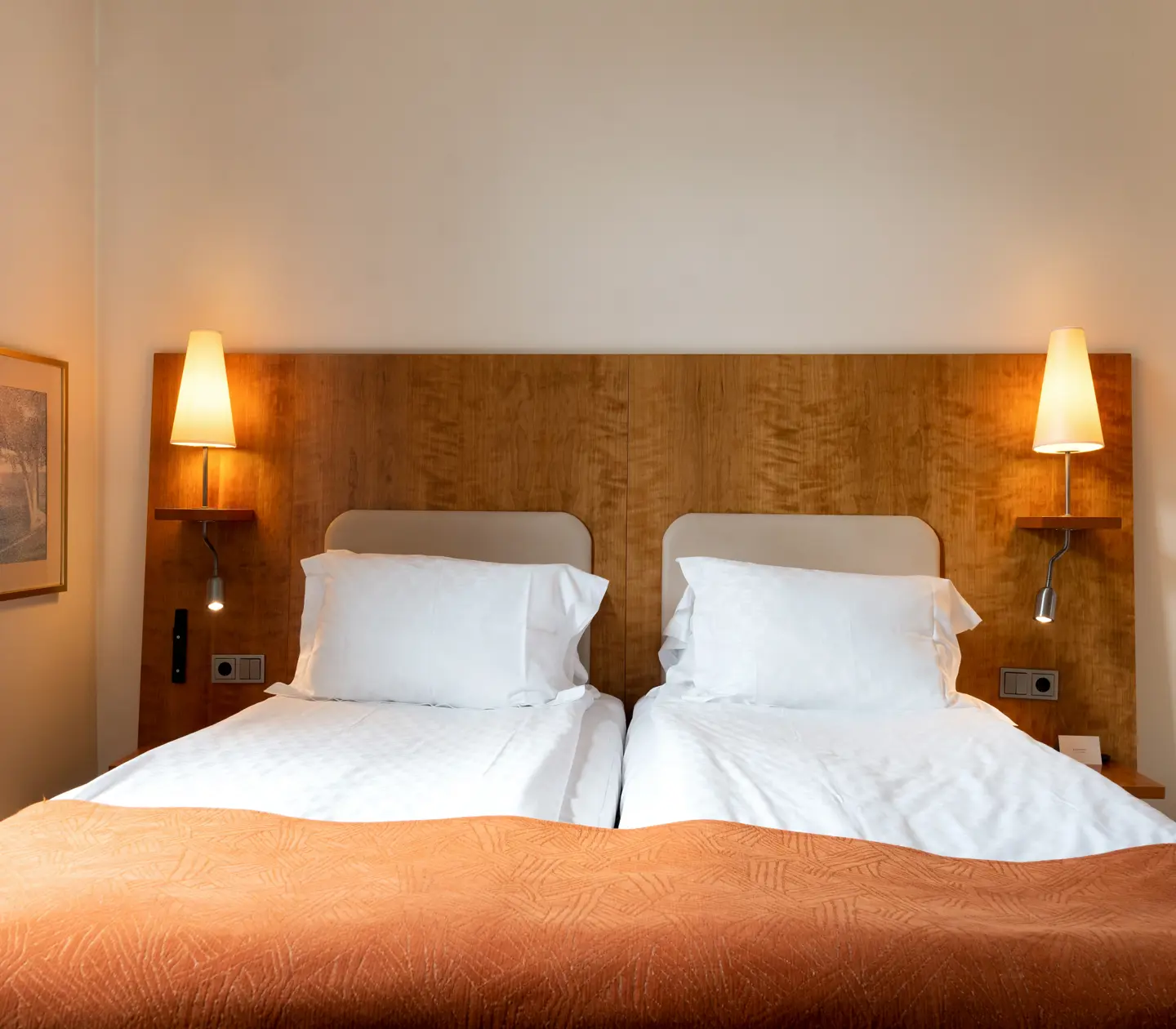 Hotellrum med dubbelsäng och sänglampor